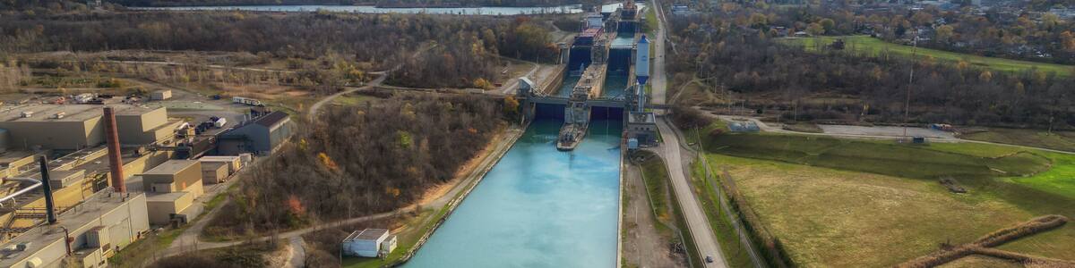 Aerial over the Welland Canal, part of the St. Lawrence Seaway and Great Lakes Waterway in St. Catharines, Ontario, Canada. Looking south towards lock 5 in Thorold. Autumn in November 2024.