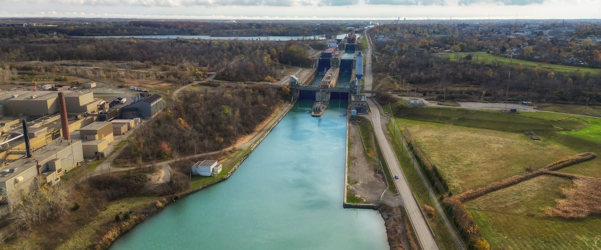 Aerial over the Welland Canal, part of the St. Lawrence Seaway and Great Lakes Waterway in St. Catharines, Ontario, Canada. Looking south towards lock 5 in Thorold. Autumn in November 2024.
