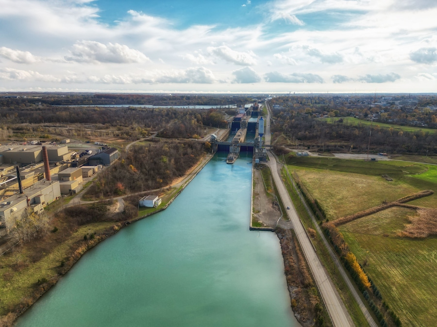 Aerial over the Welland Canal, part of the St. Lawrence Seaway and Great Lakes Waterway in St. Catharines, Ontario, Canada. Looking south towards lock 5 in Thorold. Autumn in November 2024.