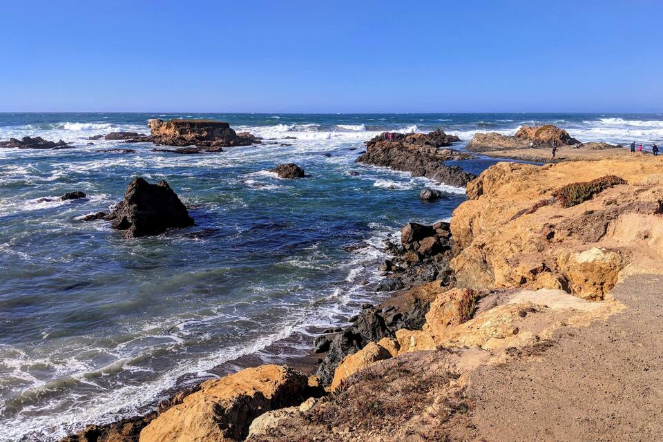A rocky coastline with waves crashing against the shore.