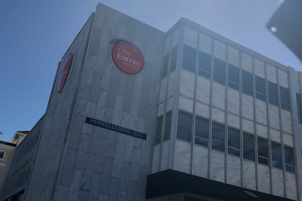 Un edifici amb una placa que diu "The One Eleven Building" i "PENNELLCHING LLC" a la seva façana.