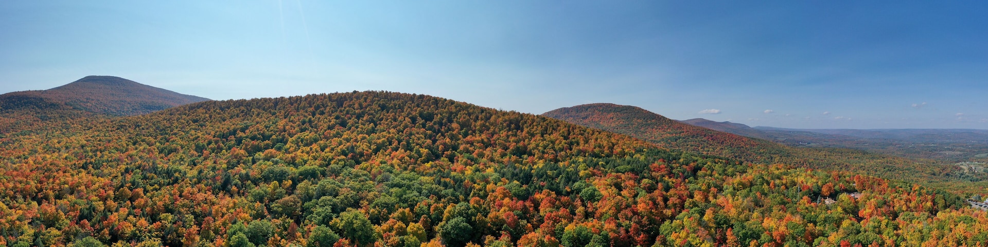 A forested mountain range with autumn foliage.
