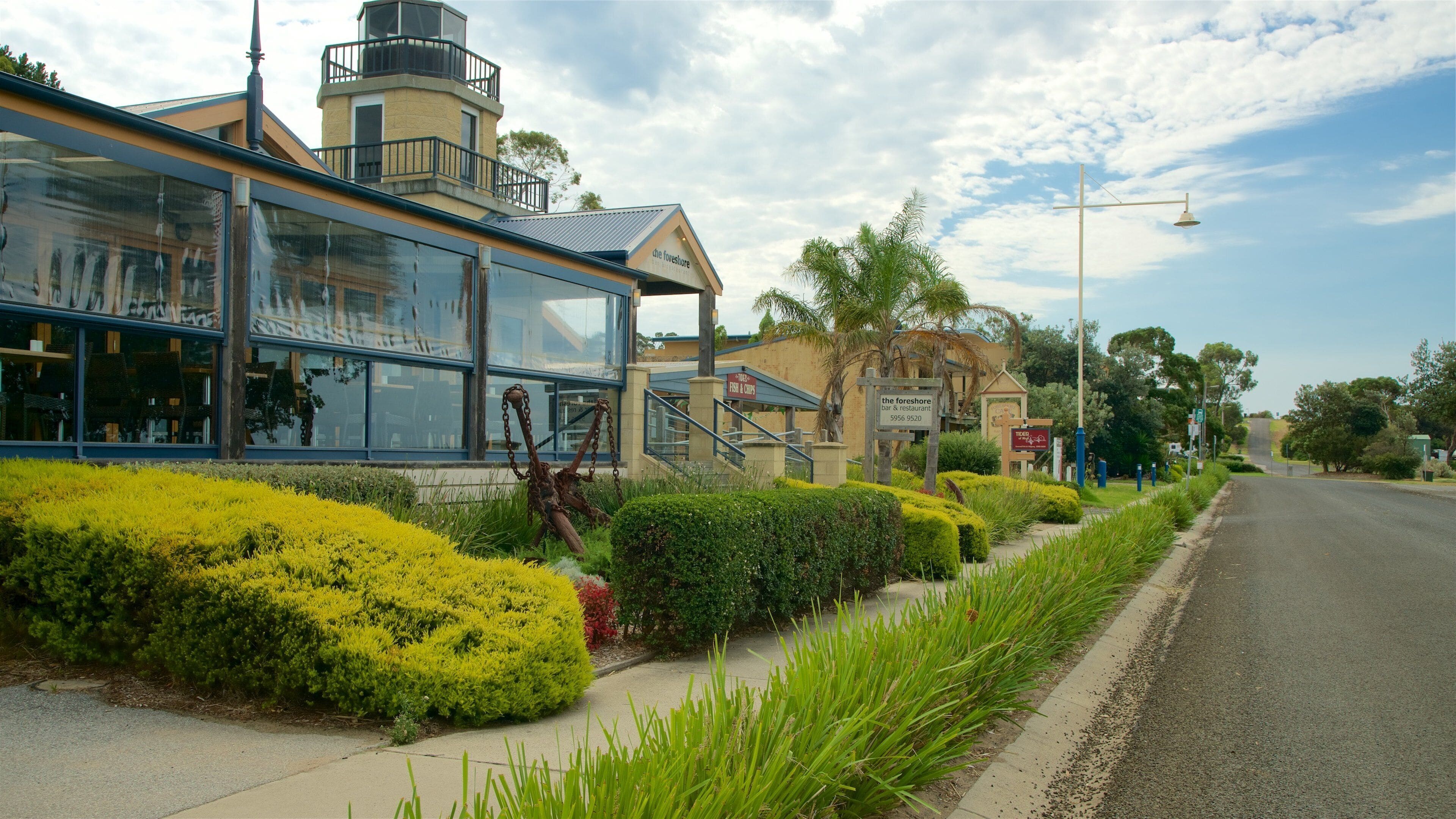 A waterfront restaurant with a glass facade and a sign reading "The Foreshore Bar & Restaurant".