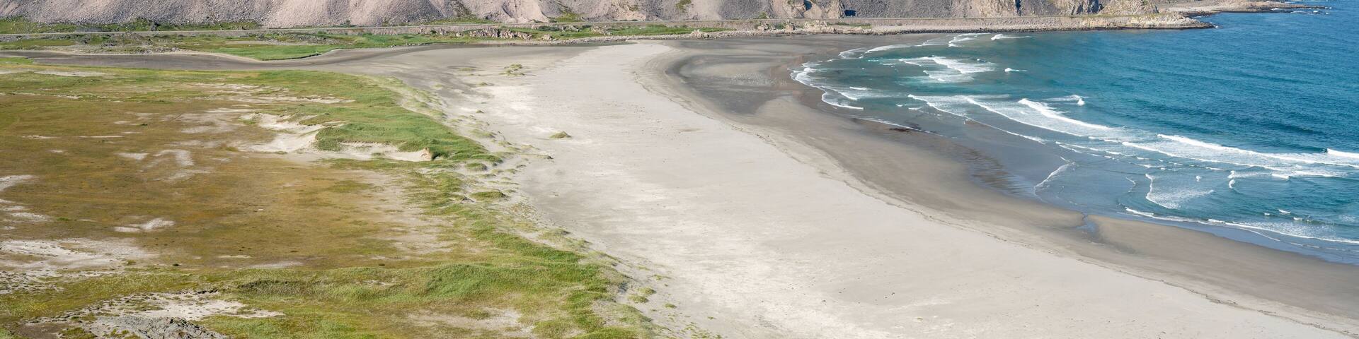 A sunny summer day in Sandfjorden beach by the Barents Sea near the town of Berlevåg, Northern Norway