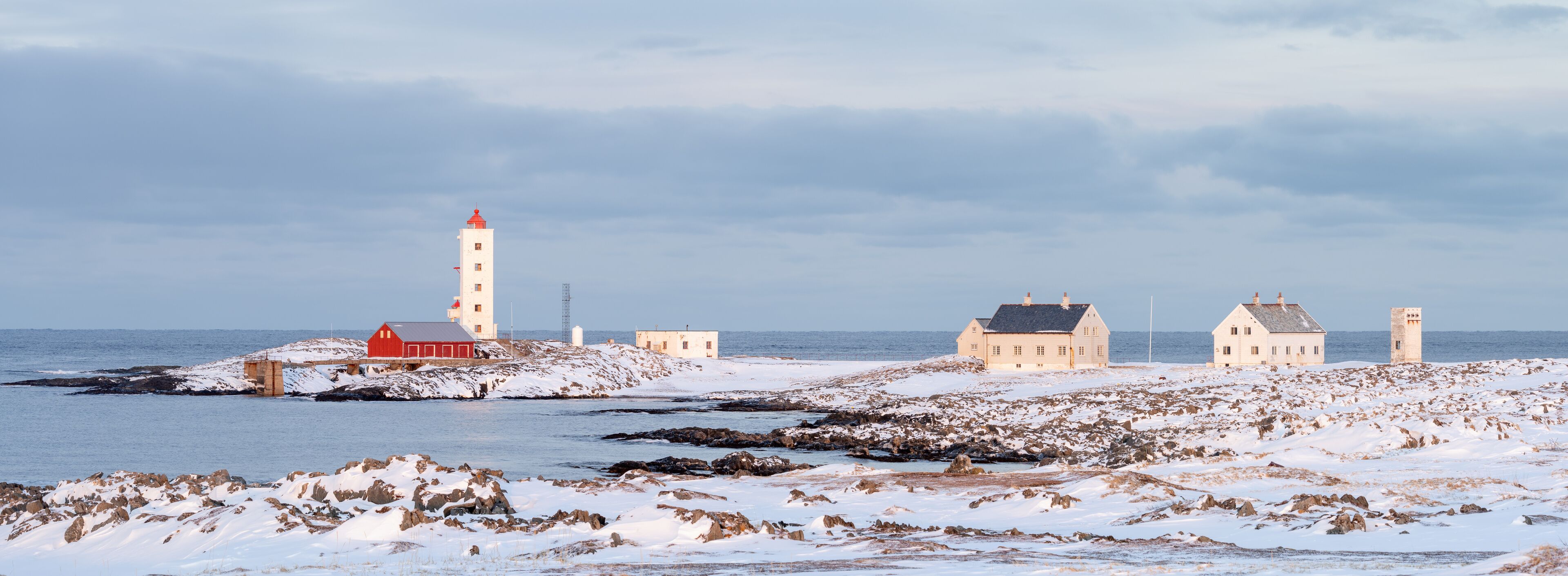 Lighthouse on the rugged coast of the Barents Sea on a moody winter evening, Berlevåg Norway