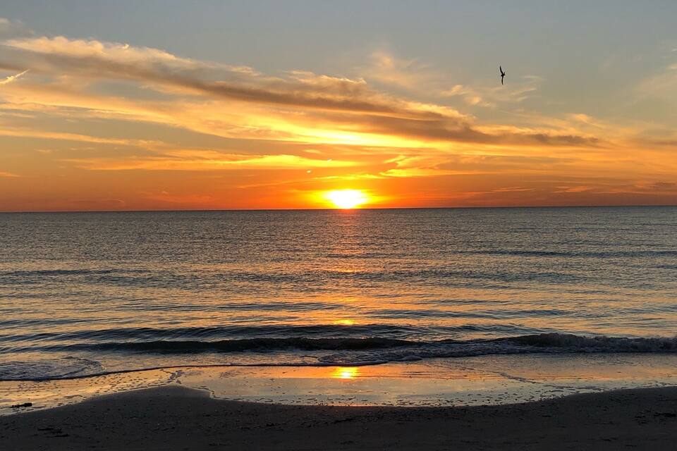 Un atardecer sobre el océano con olas en la orilla.