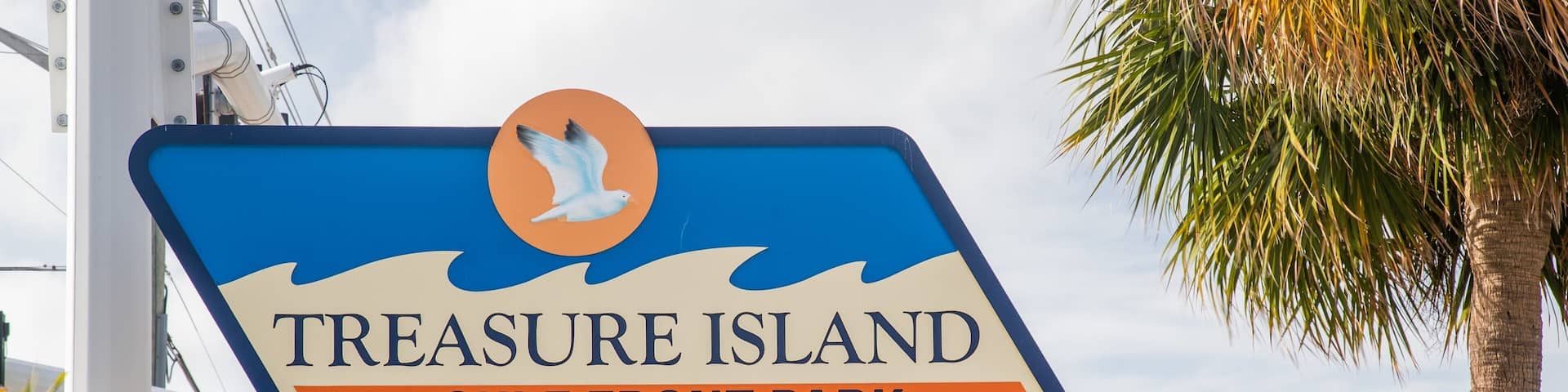 A sign for Treasure Island Gulf Front Park with a seagull illustration.