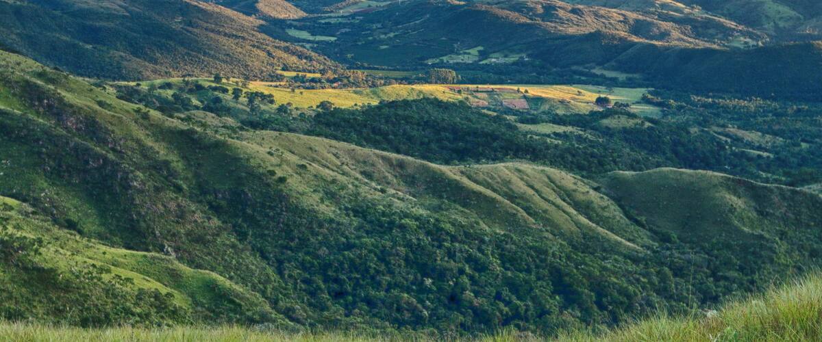 Rolling hills, a valley, and distant mountains.