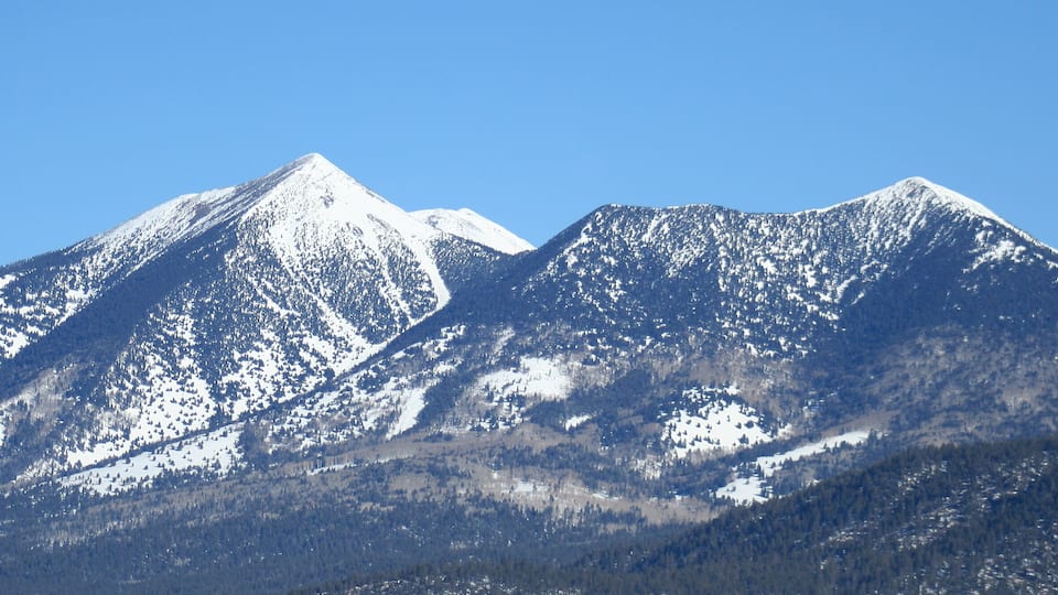 A snow-covered mountain range with clear skies.