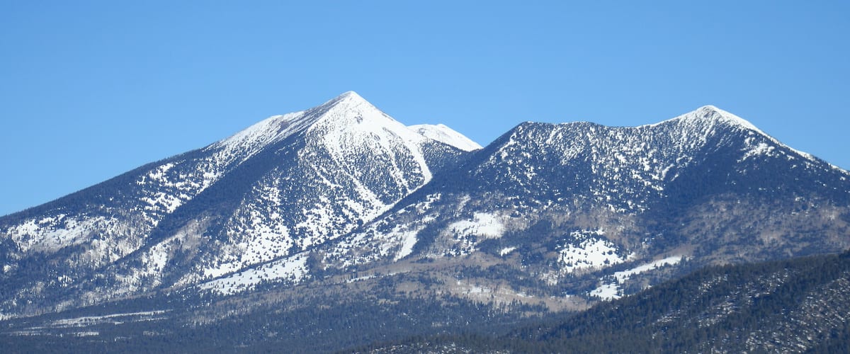 A snow-covered mountain range with clear skies.