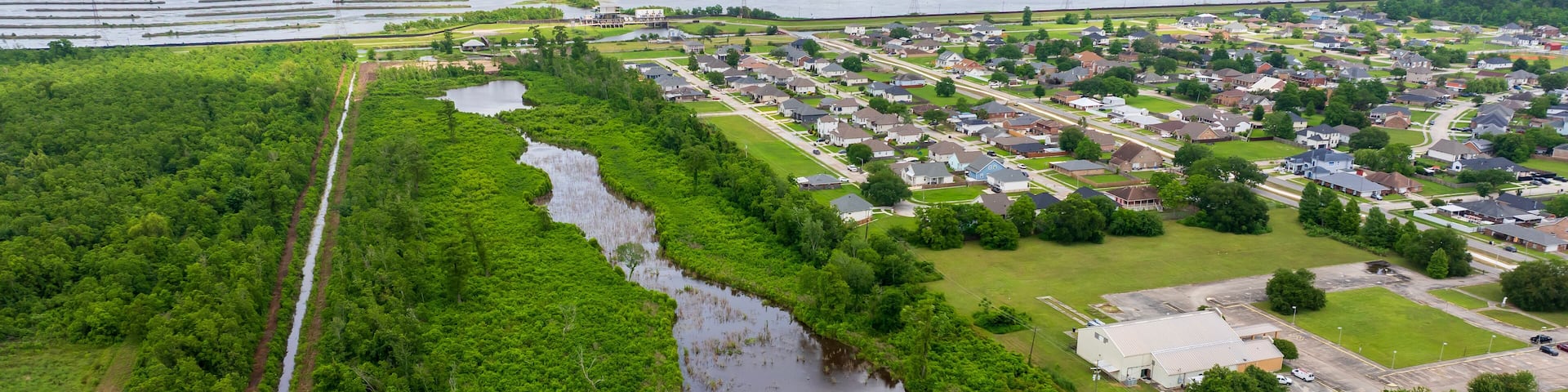 aerial shot of homes and marshland with water and lush green trees in Chalmette Louisiana USA