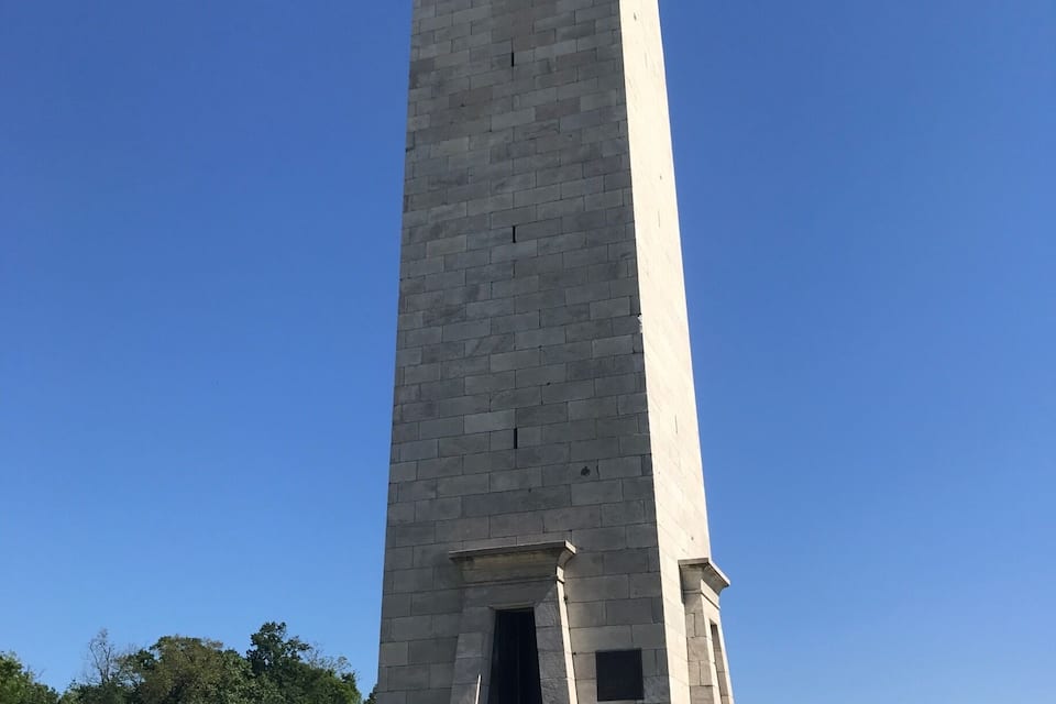 A tall, rectangular monument with a staircase leading up to its entrance.