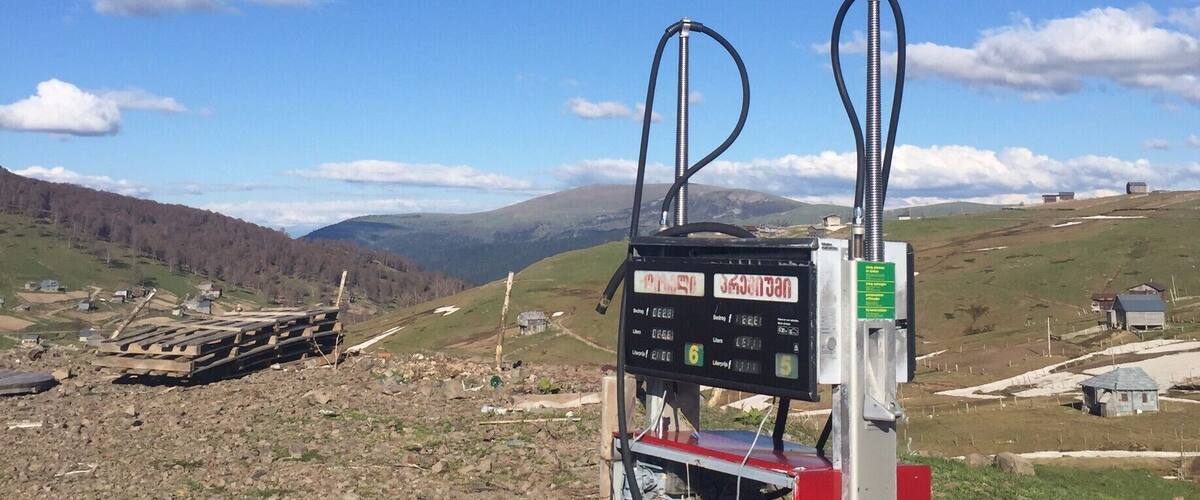 A gas station with a mountainous landscape in the background.