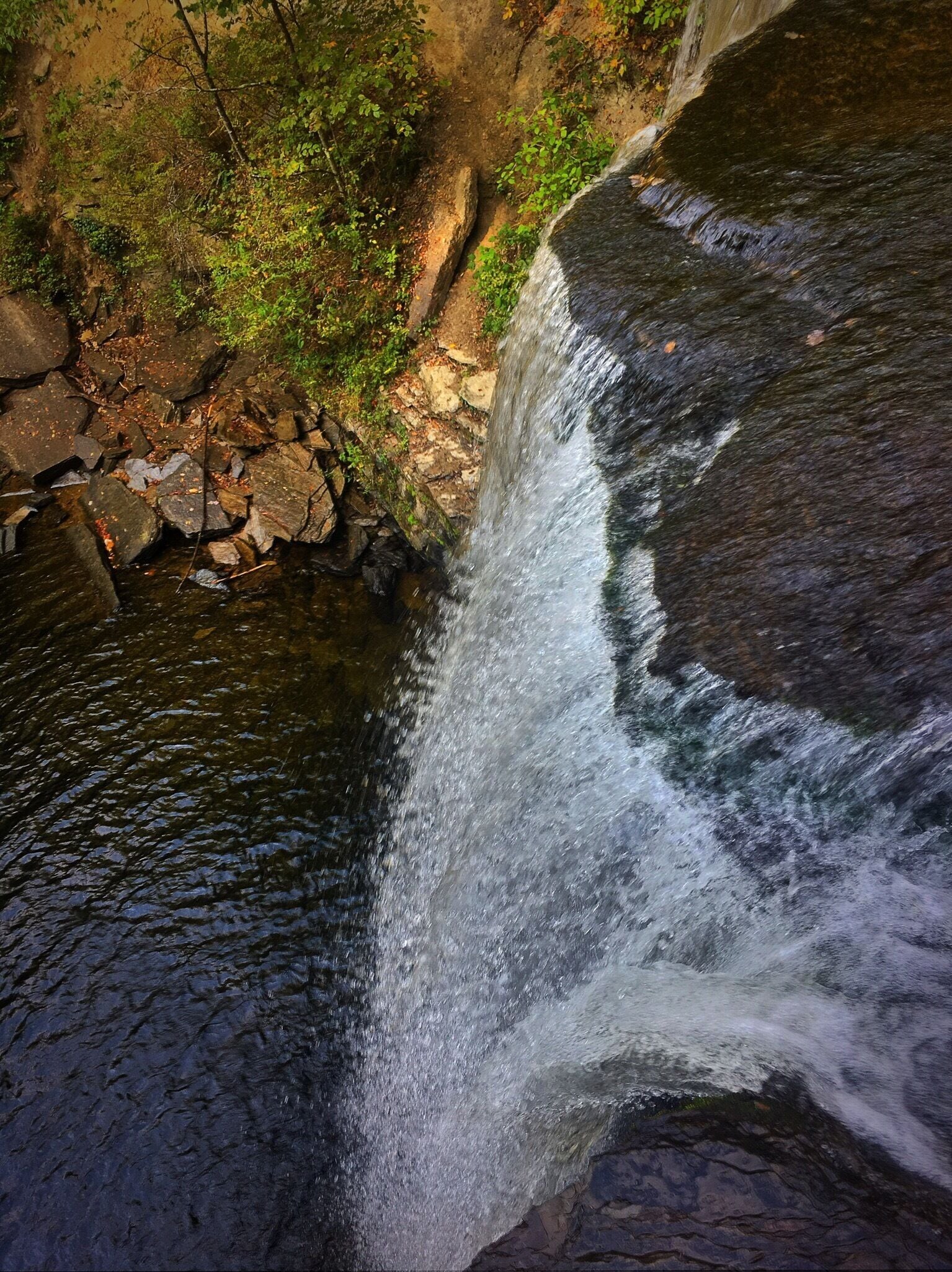 A waterfall cascading over rocks in a forested area.