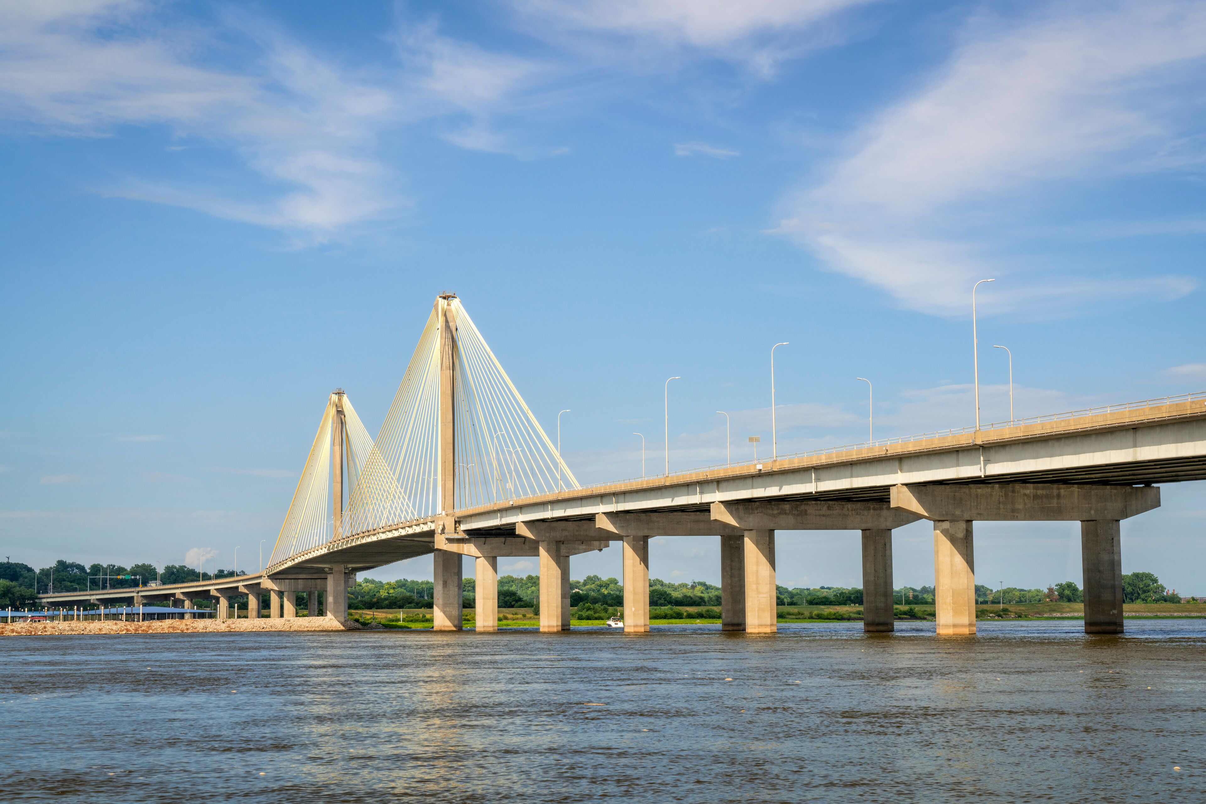 A cable-stayed bridge over a river with a clear sky.