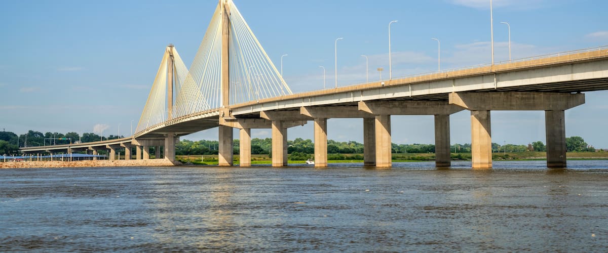A cable-stayed bridge over a river with a clear sky.