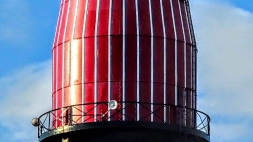 Eine hohe, zylindrische Struktur mit rot-weiß gestreiftem Muster und dem Schriftzug "Brock's Old Original Catsup".