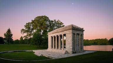 Tranquil sunset moon rising landscape at Temple to Music Pavilion and meadow forest park at Roger Williams Park in Providence, Rhode Island, pink horizon and water reflections on Cunliff Lake