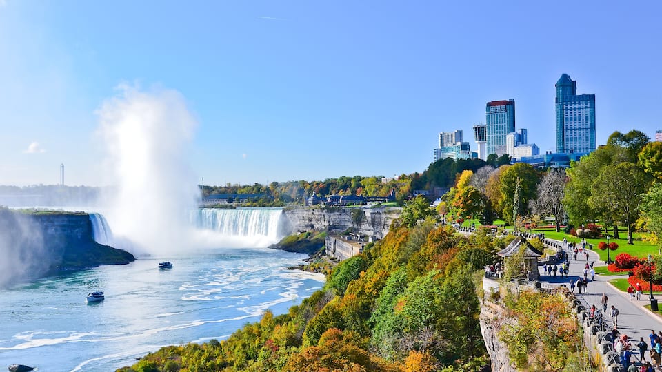 A waterfall, a park with people, and a city skyline.