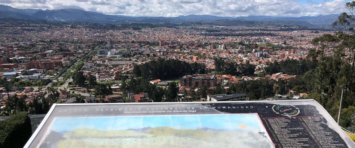 A cityscape with mountains in the background and a large map on a table in the foreground.