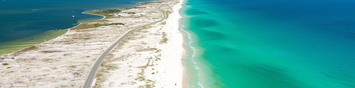 A coastal road with a beach and turquoise waters.