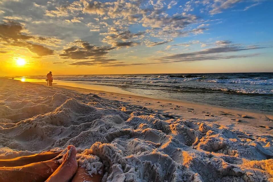 Una playa al atardecer, con arena y olas.