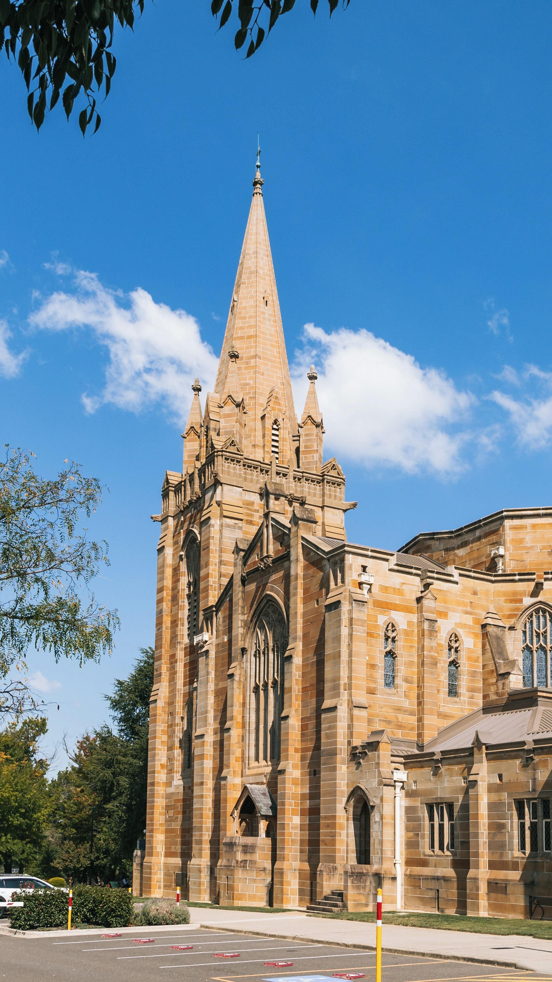 A large, historic church with a tall, pointed spire and intricate stonework.