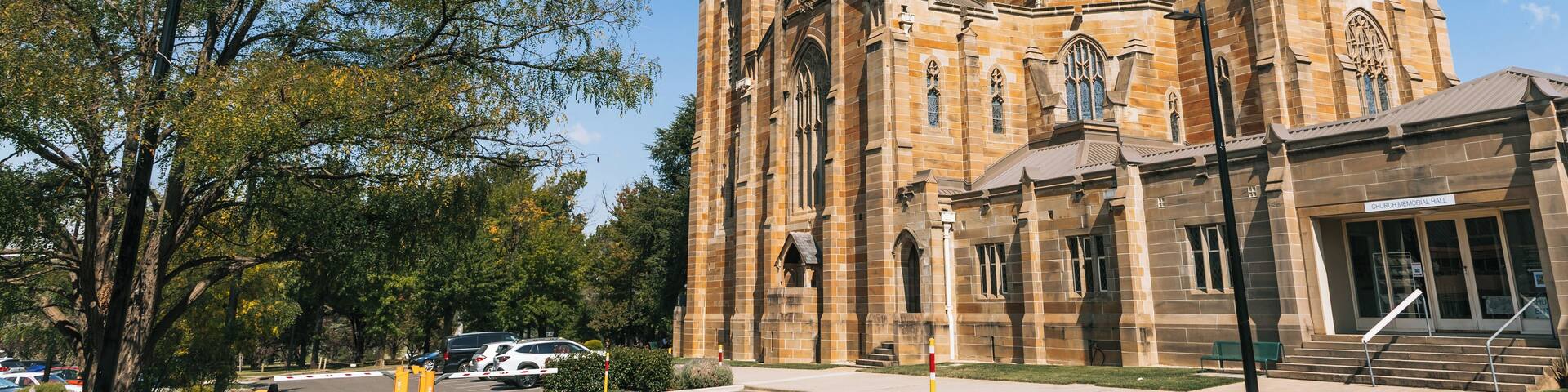 A large church with a tall spire, a stone facade, and a smaller building labeled 'Church Memorial Hall' adjacent to it.