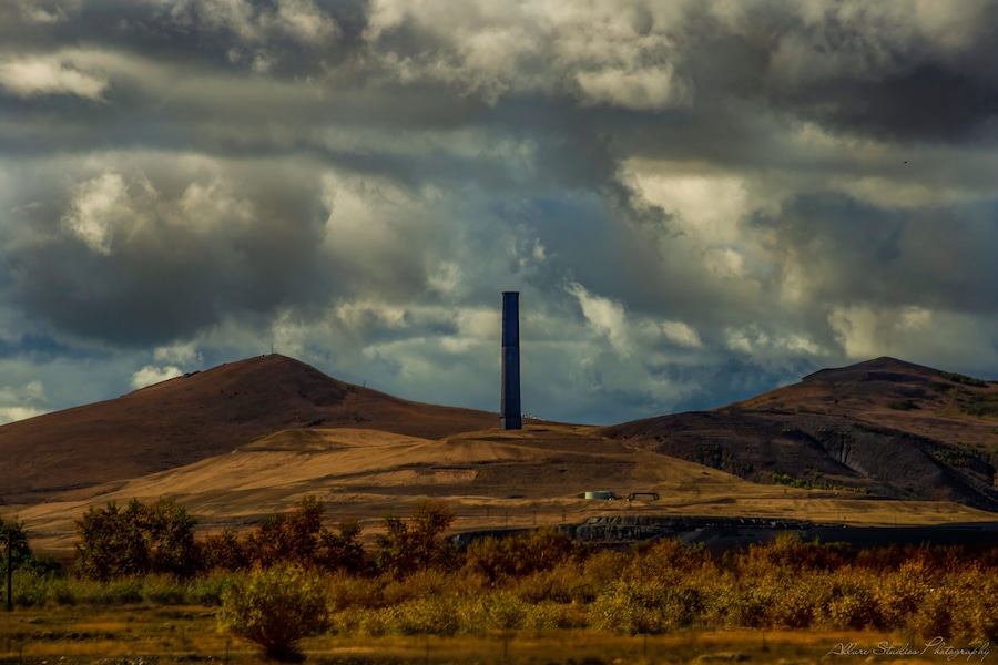 Una torre solitaria en medio de colinas ondulantes bajo un cielo nublado.