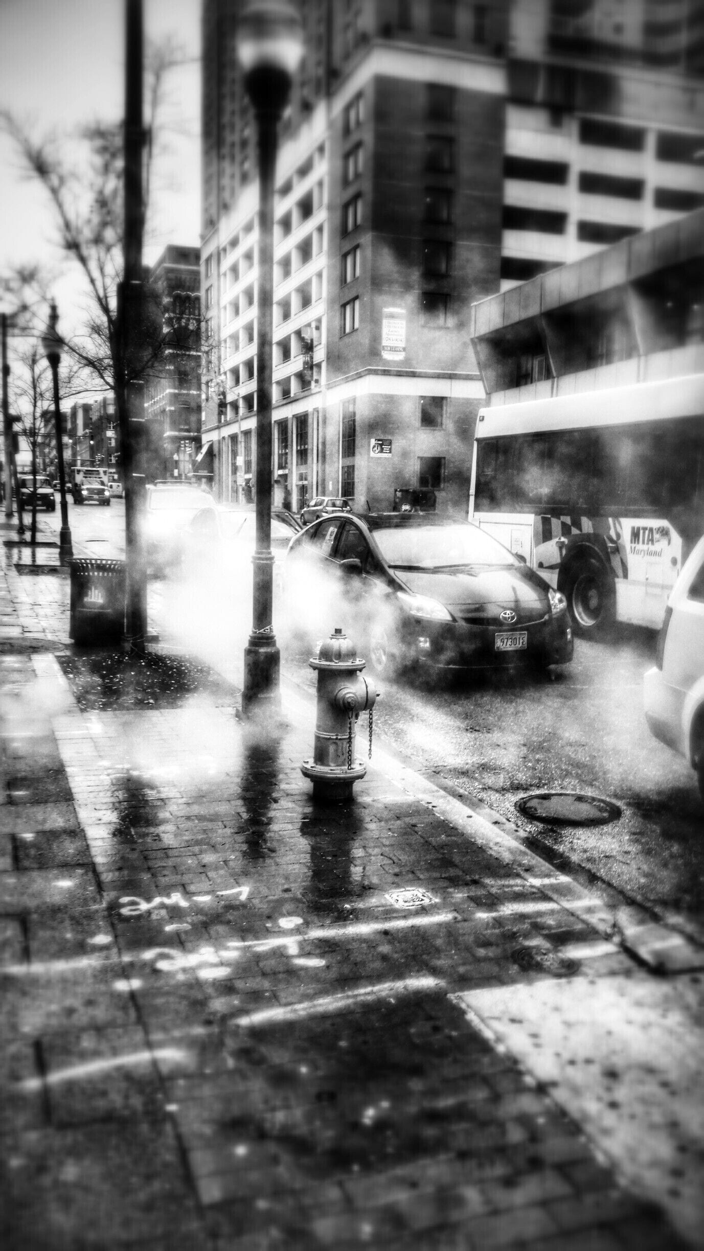 Taken during a walk around downtown Baltimore on a cold rainy December morning. Clouds of steam billowing from manhole covers helped set the mood for the Tuesday morning commute.