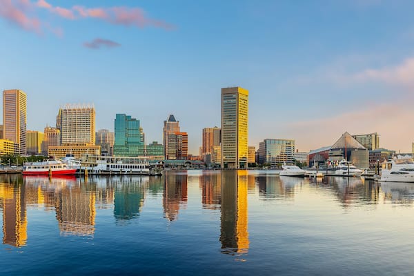 A city skyline with high-rise buildings and a marina with boats.