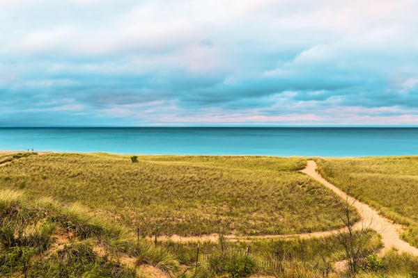People walking the beach in New Buffalo Michigan by the dunes before it rains