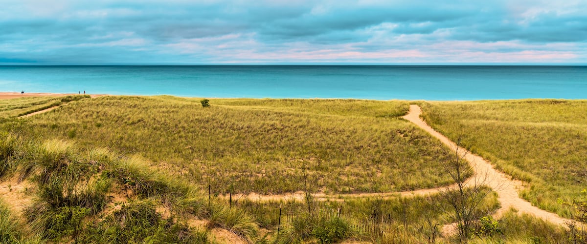 People walking the beach in New Buffalo Michigan by the dunes before it rains
