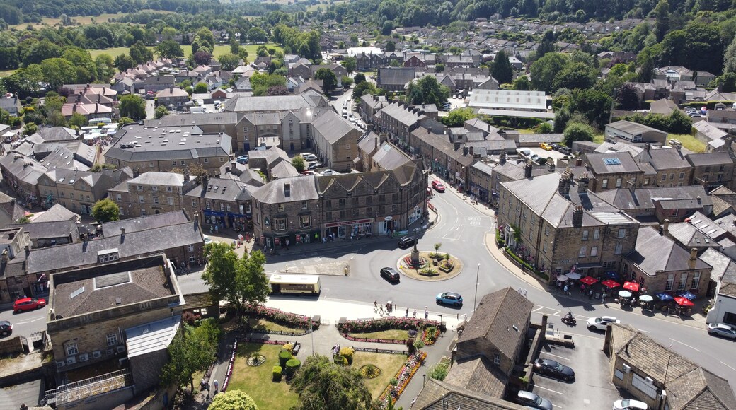 A town square surrounded by historic buildings, a roundabout, and a river in the background.