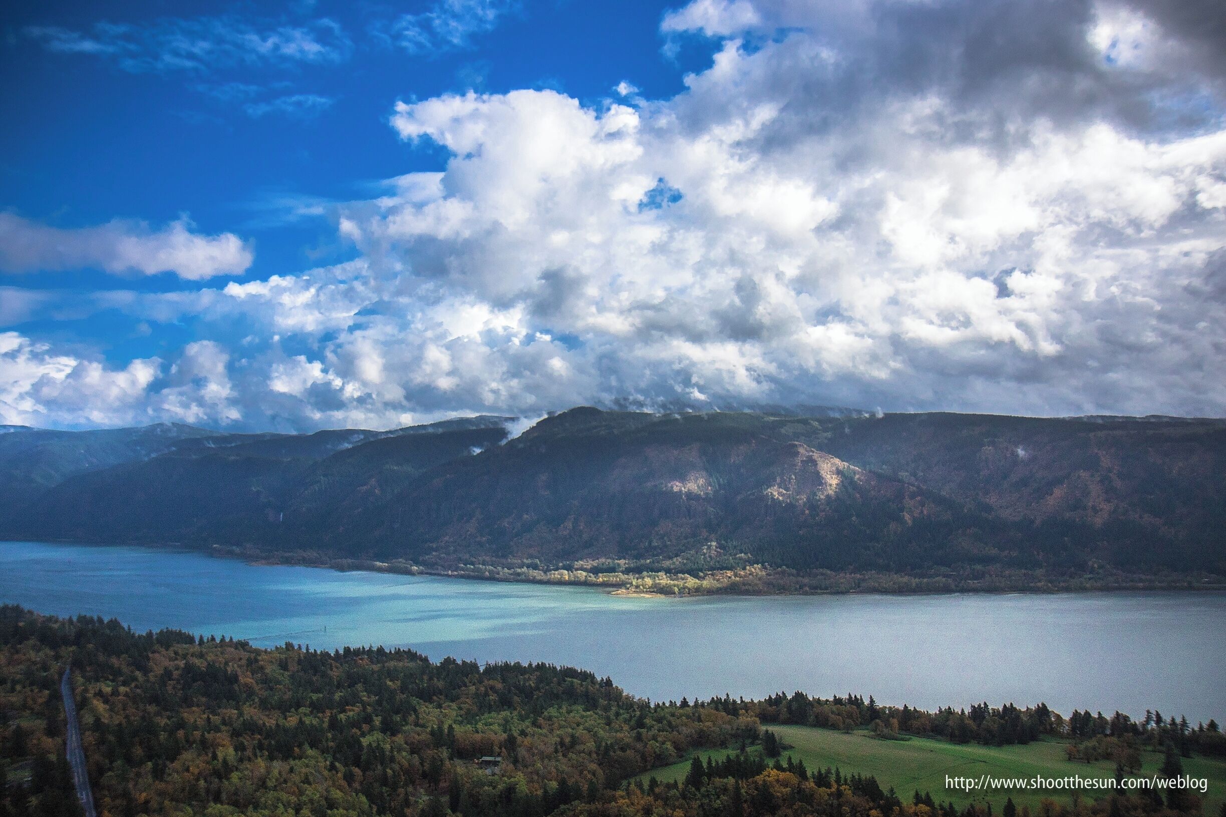 A lake surrounded by mountains and a forested area.