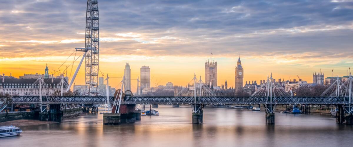 A river with a bridge, a Ferris wheel, and the Big Ben clock tower.