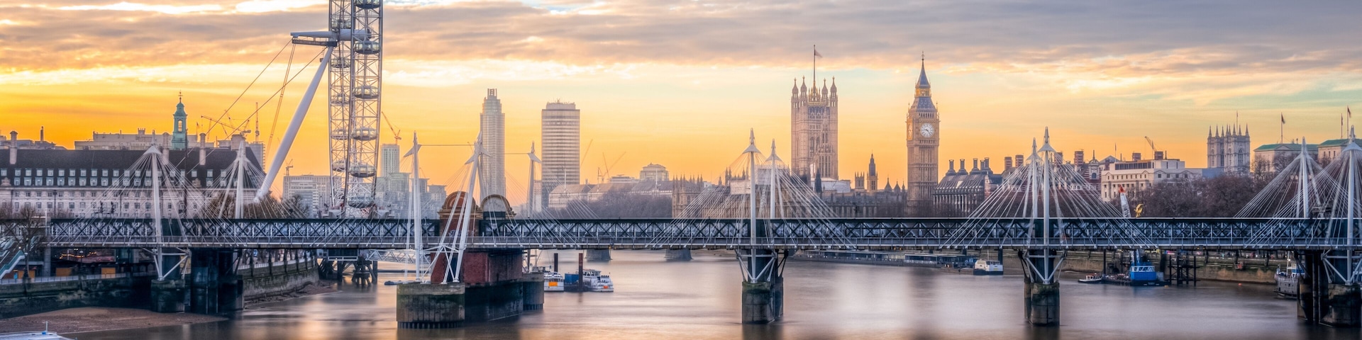 A river with a bridge, a Ferris wheel, and the Big Ben clock tower.