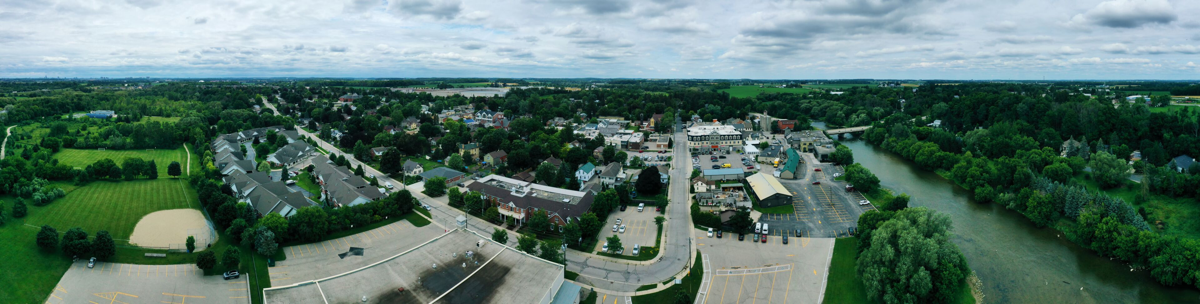 A town with a river, green parks, and a mix of residential and commercial buildings.
