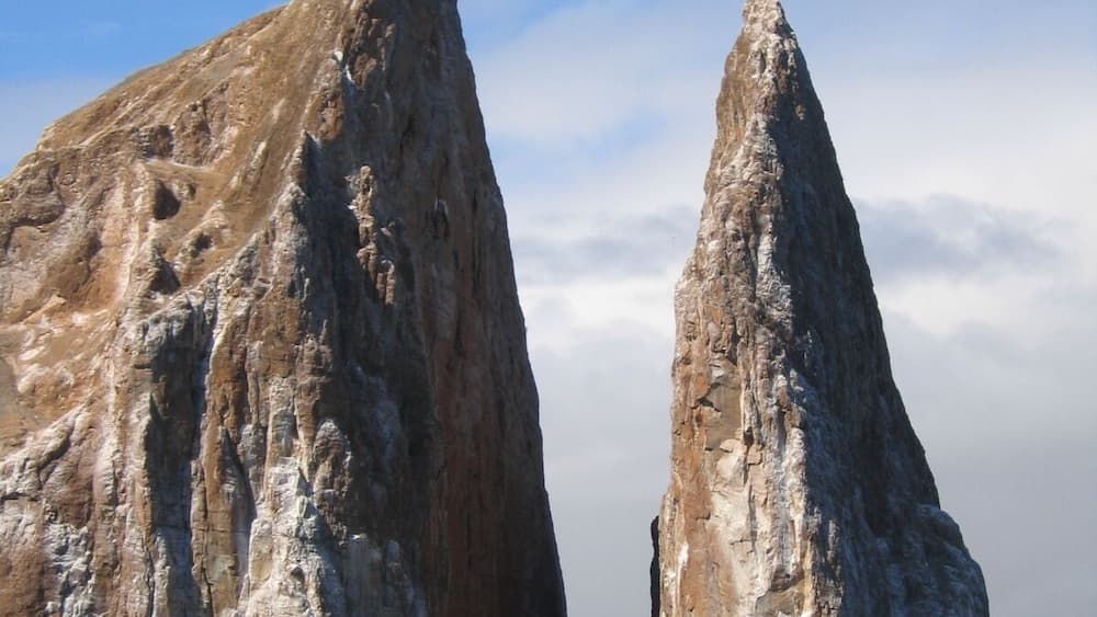 Two large rock formations in a body of water.