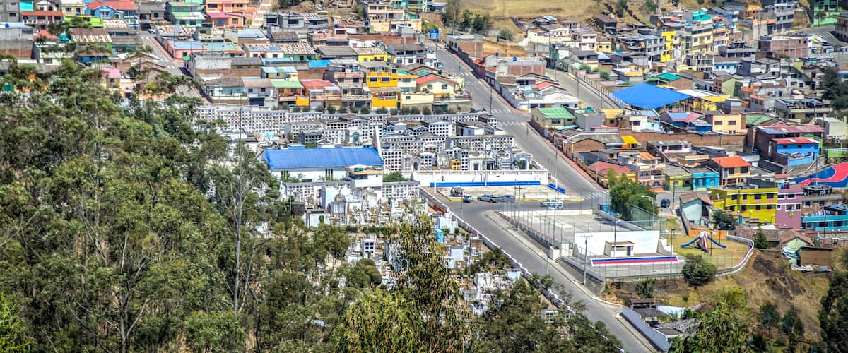A densely populated town with colorful buildings and a prominent industrial area.