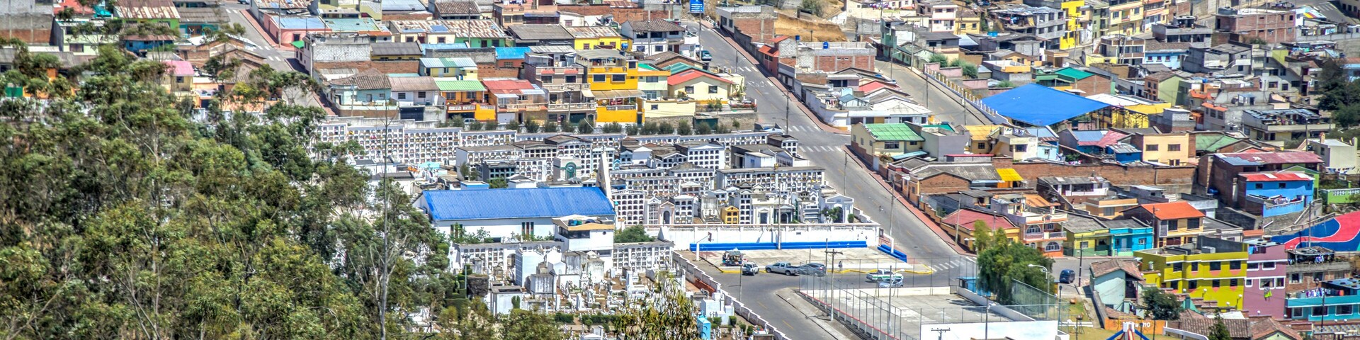 A densely populated town with colorful buildings and a prominent industrial area.