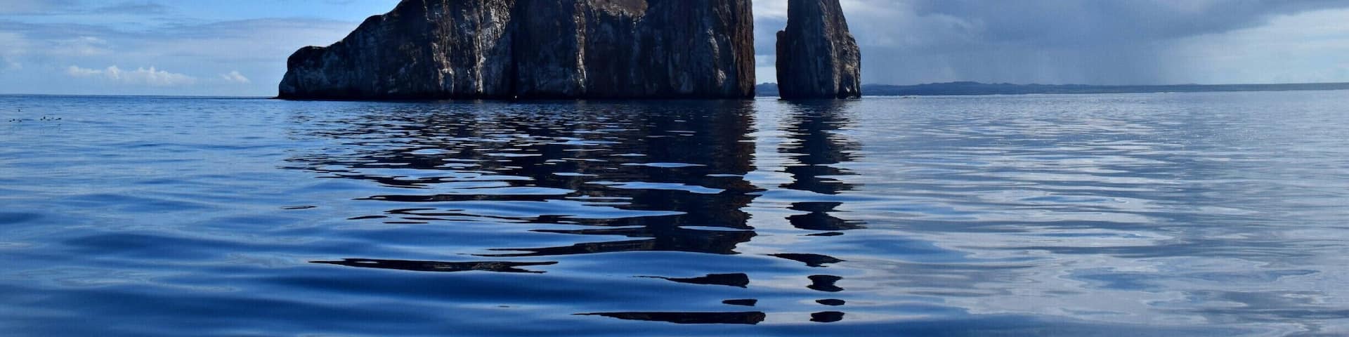 Kicker Rock, off the coast of San Cristobal Island in the Galapagos, stands 465 feet above the water. It is huge once you're up close. The snorkeling is top notch. Tons of sea turtles, sea lions, reef sharks, and though I didn't see any, hammerheads. Worth a day trip!