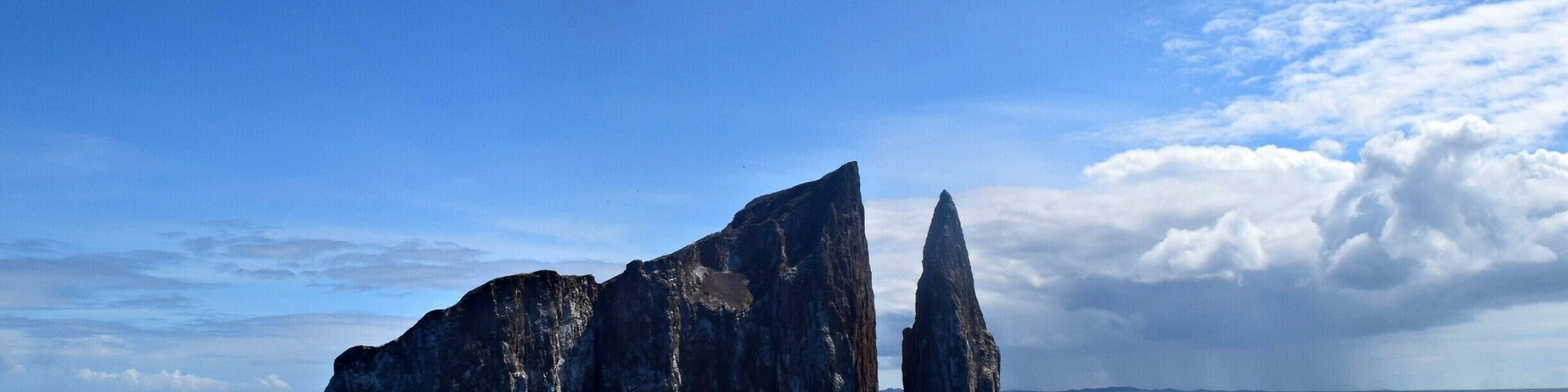Kicker Rock, off the coast of San Cristobal Island in the Galapagos, stands 465 feet above the water. It is huge once you're up close. The snorkeling is top notch. Tons of sea turtles, sea lions, reef sharks, and though I didn't see any, hammerheads. Worth a day trip!