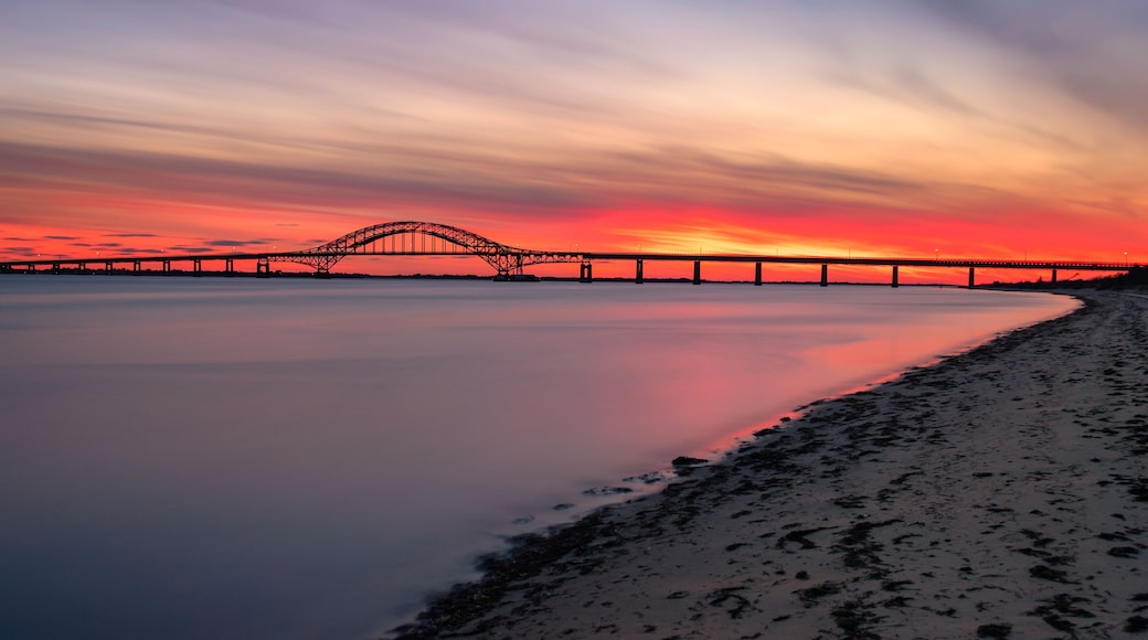 Smooth glassy water under steel tied arch bridge. Fire Island Inlet Bridge, Captree State Park New York