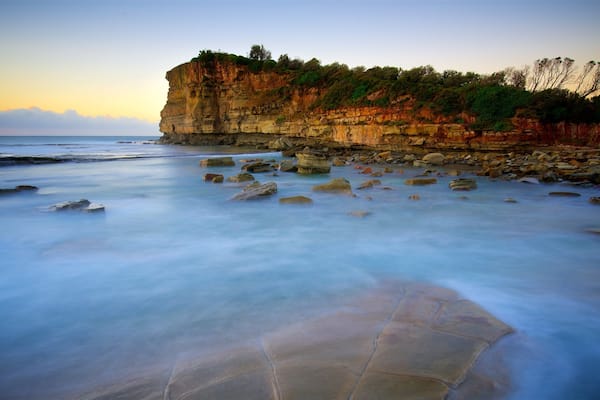 Terrigal featuring a bay or harbor, a sunset and rocky coastline