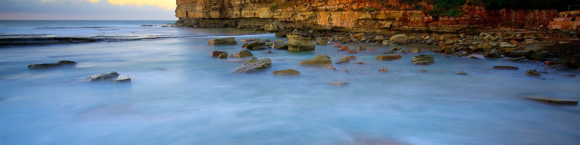 Terrigal featuring a bay or harbor, a sunset and rocky coastline