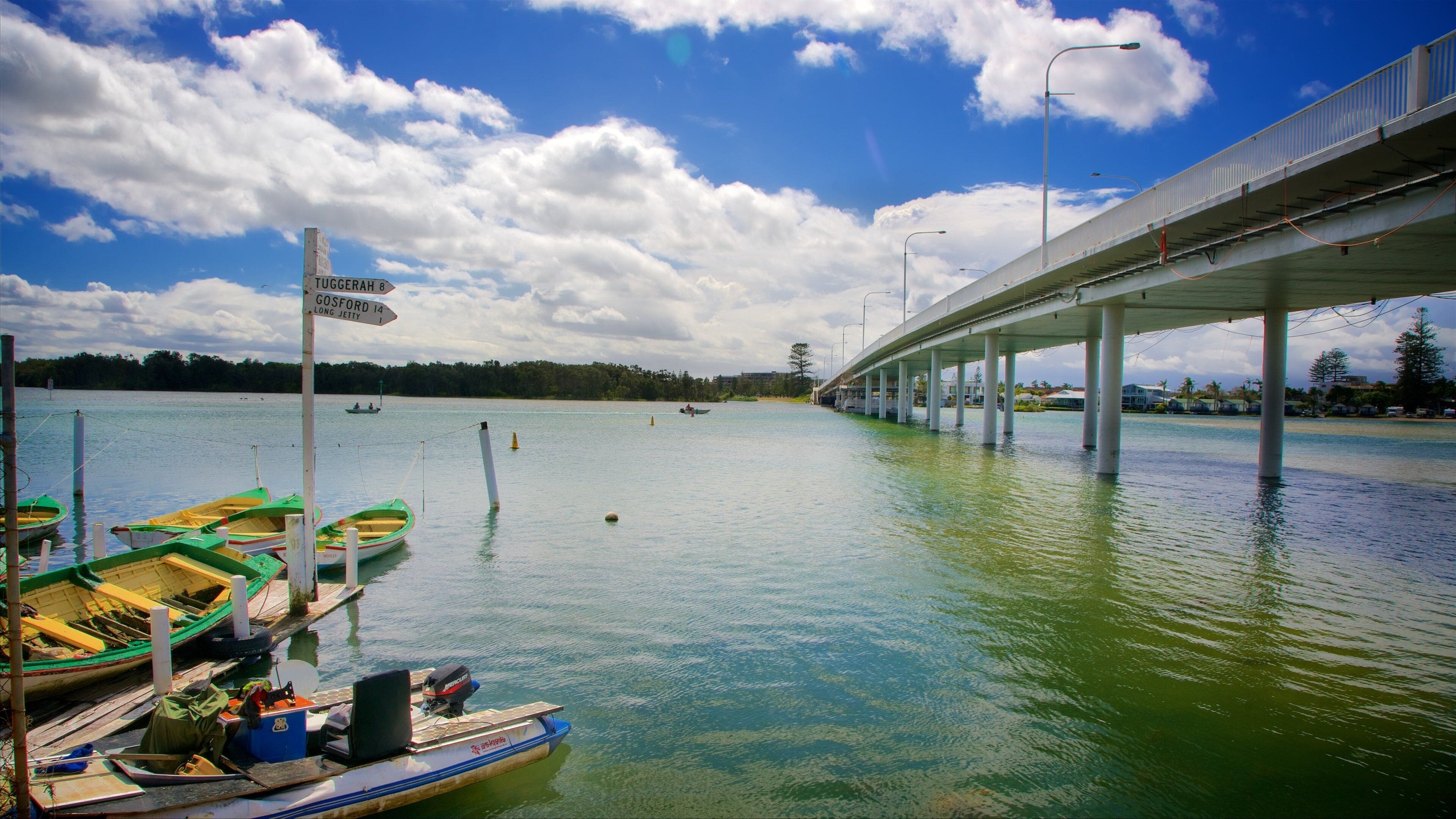 A bridge over water with boats docked at the pier.