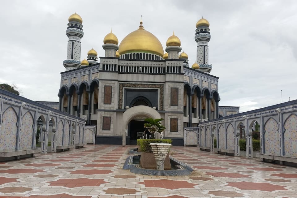 A mosque with golden domes and intricate tile work.