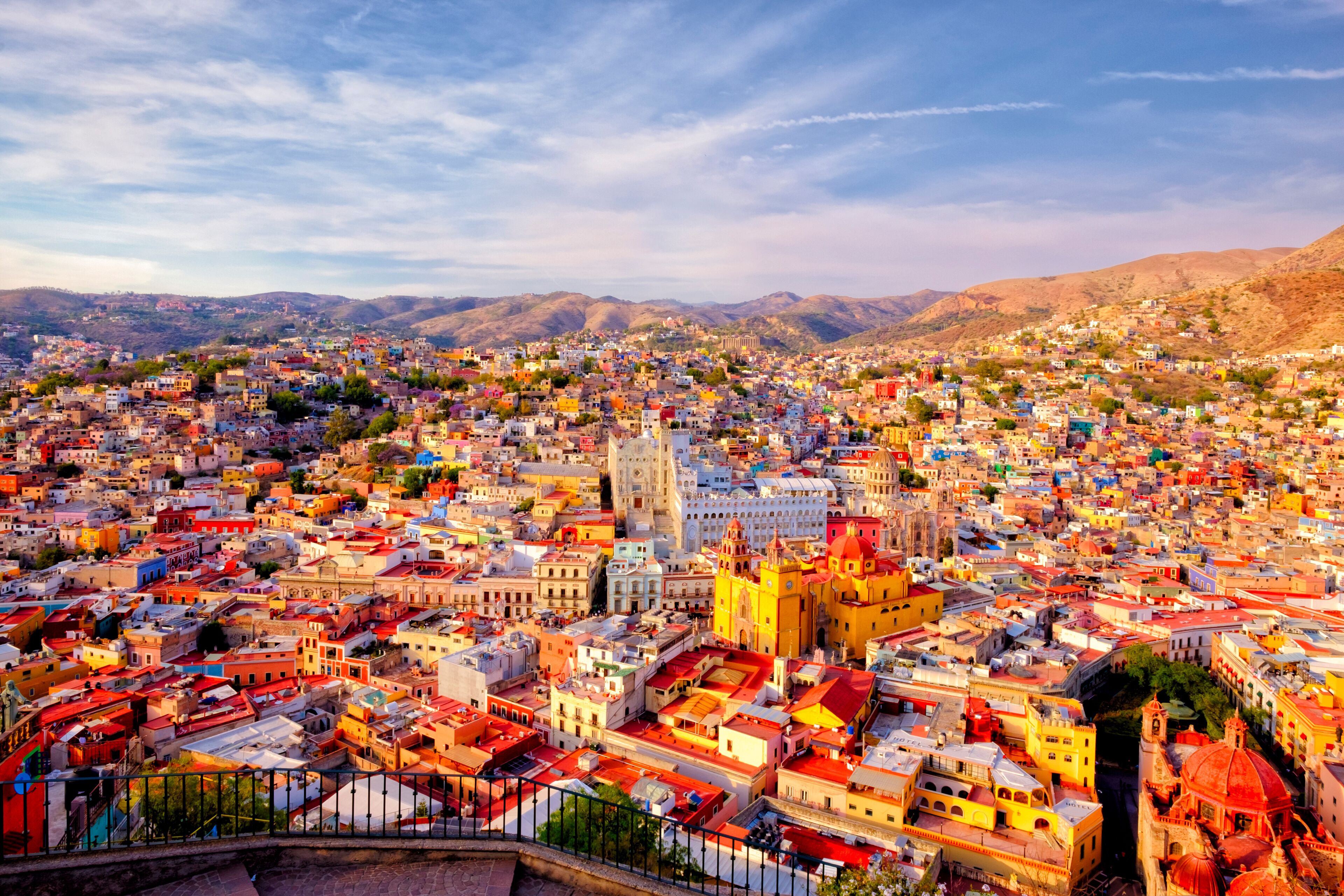 A densely packed cityscape with a prominent yellow church and surrounding colorful buildings.