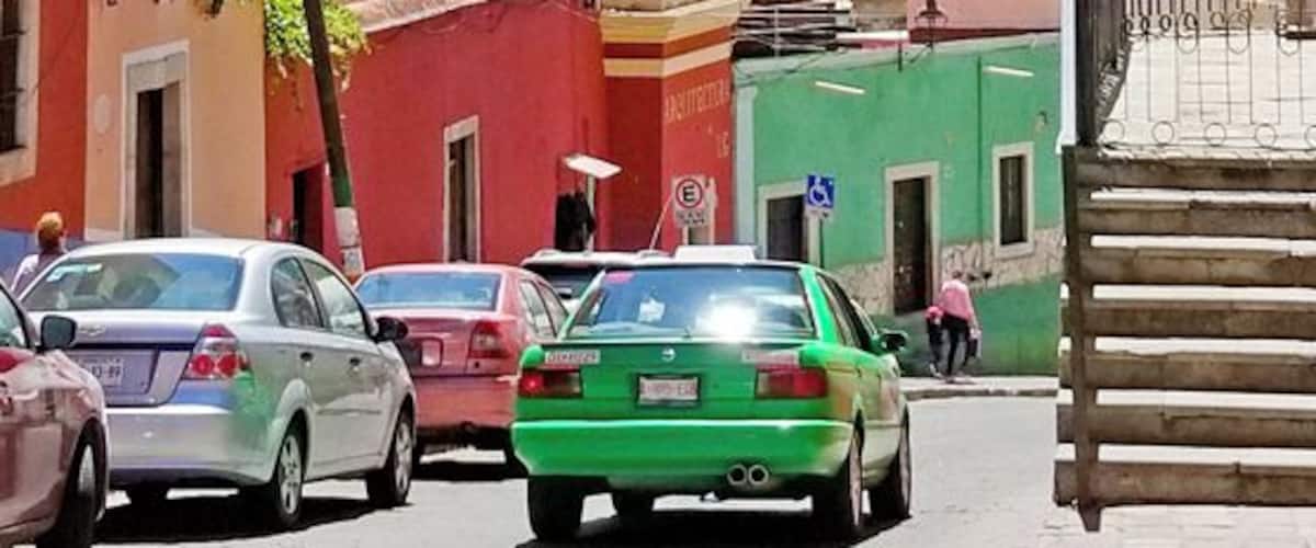 Green taxis, purple trees, golden churches, rainbow houses - the view from the side steps of the Alhondiga, down to the Mercado Hidalgo.